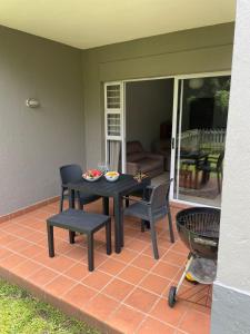 een patio met een tafel en stoelen op een veranda bij The Flip Flop Stop in Ballito +4 foto's