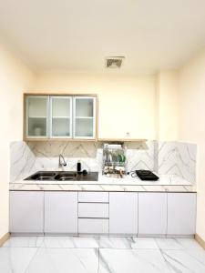 Una cocina con gabinetes blancos y un fregadero. en Hotel Asia Express near Farmhouse Lembang, en Lembang