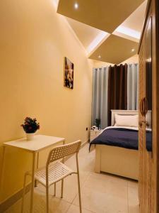 Un dormitorio con una cama, una mesa y una silla. en DSV Property, en Abu Dabi