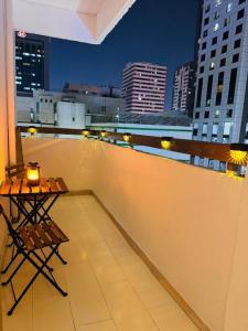 Una mesa en un balcón con vista a una ciudad. en DSV Property, en Abu Dabi