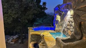a water slide at a resort with a waterfall at Bait Falaj Al Misfah Hospitality in Misfāh