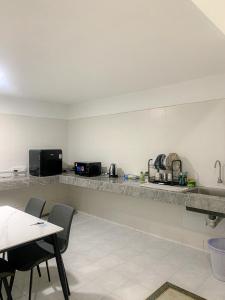 Una cocina con encimera y mesa con sillas. en Mekla Hotel Studio Apartment, en Gua Musang