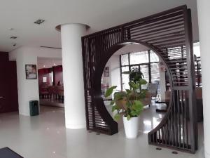 a hallway with a spiral staircase with a potted plant at Jinjiang Inn Shaoxing Shengli West Road Luxun Hometown in Shaoxing