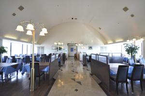 une salle à manger avec des tables et des chaises et un grand plafond dans l'établissement Hotel Tamai, à Aki