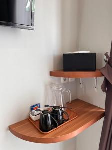 een houten plank met twee kopjes en een blender erop bij Aluna Bay Hotel in Balige