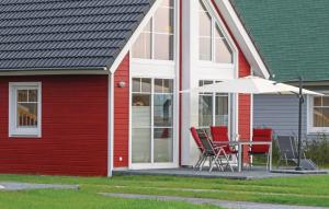a red and white house with a table and an umbrella at Haus Hafenidyll in Wandlitz