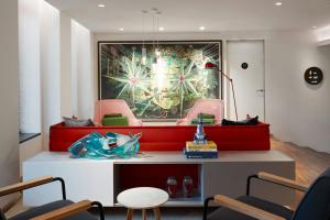 a waiting room with pink chairs and a painting at citizenM Amstel Amsterdam in Amsterdam