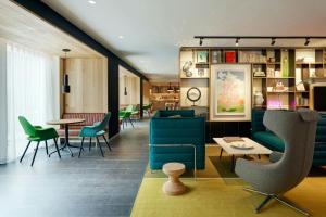 a lobby with green chairs and a table at citizenM Amstel Amsterdam in Amsterdam