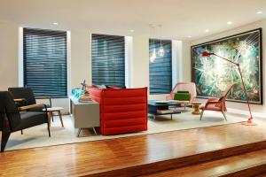 a living room with a red cabinet and chairs at citizenM Amstel Amsterdam in Amsterdam +29 photos