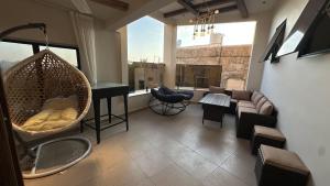 a living room with a hanging hammock in a room at Bait Falaj Al Misfah Hospitality in Misfāh