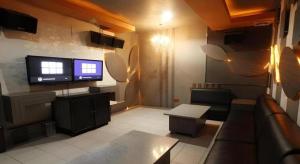 Una sala de estar con un sofá y un televisor de pantalla plana. en Hotel Banjarmasin International, en Benuaanyar