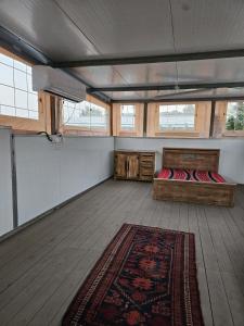 a room with a bed and a rug on a boat at חאן בשביל היער in Ta‘oz