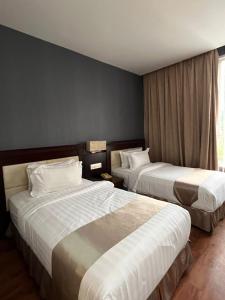 a hotel room with two beds and a window at Kingston Hotel 18 - Kuala Lumpur Sri Damansara in Kuala Lumpur +59 photos