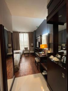 a hotel room with a bed and a living room at Kingston Hotel 18 - Kuala Lumpur Sri Damansara in Kuala Lumpur