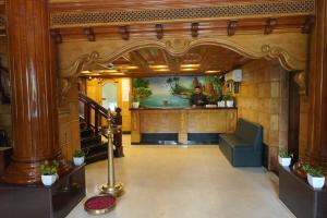a lobby with a couch and a painting on the wall at skypalace hotel in Kannur