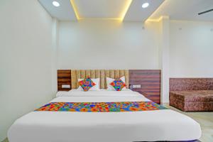 Un dormitorio con una gran cama blanca y un sofá. en FabHotel SS Inn, en Indore