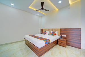 Un dormitorio con una cama y un ventilador de techo. en FabHotel SS Inn, en Indore