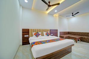 Un dormitorio con una cama grande y un sofá. en FabHotel SS Inn, en Indore