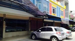 Un coche plateado aparcado frente a un edificio en H3 Hotel, en Tanjung Balai Karimun