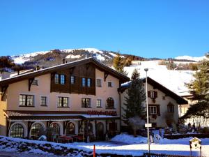 a large house with snow on the ground at B&B Bela Riva in Savognin