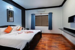 een slaapkamer met een groot bed met blauwe muren bij Siem Reap Urban Boutique Hotel in Siem Reap