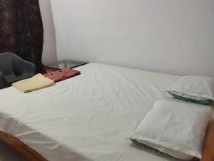 尼尔岛Sea Sand Resort的一张铺着白色床单和枕头的床