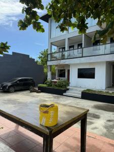 een bankje met een gele mand erop voor een gebouw bij Bonbon Beach House in Liloan