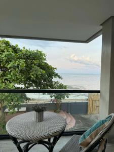 een tafel en stoelen op een balkon met uitzicht op de oceaan bij Bonbon Beach House in Liloan