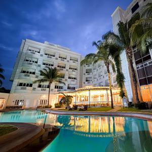 a hotel with a swimming pool in front of a building at Madison Crown Hotel in Angeles