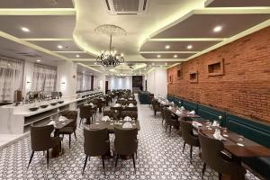 a restaurant with tables and chairs and a brick wall at Madison Crown Hotel in Angeles