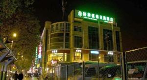 GreenTree Inn Shanghai Hongqiao Hub Convention Center Jinghua Road Shell Hotel في Fangjiayao: مبنى عليه علامة في الليل