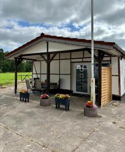 un padiglione con due panchine e fiori al suo interno di Gemütliches Ferienhaus im Grünen a Beverstedt