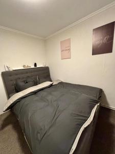 una camera da letto con un letto con copriletto grigio di Gemütliches Ferienhaus im Grünen a Beverstedt Altre 3 foto