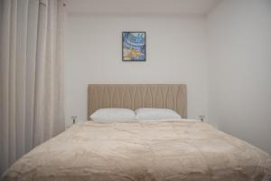 a bedroom with a large bed with two pillows at Phenix Apartments Lux Parking FREE in Podgorica +19 photos