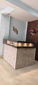 Un mostrador de metal en una habitación con una pared. en Royal inn, en Patna