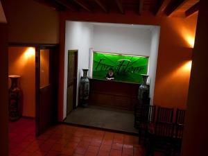 uma pessoa sentada em um bar em uma sala com uma tela verde em Forest Floor Lodge em Tân Phú