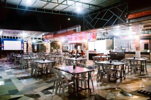a restaurant with tables and chairs in a room at The Golden Bay Hotel Batam in Sengkuang