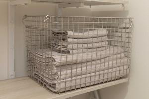 a wire rack with folded towels on a shelf at Nagoya Hanezu in Nagoya