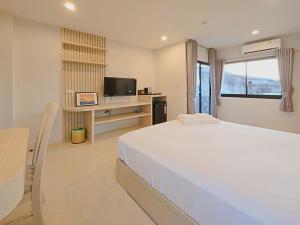 een slaapkamer met een groot bed en een televisie bij Maraya Residence มารอยา เรสซิเดนซ์ in Bang Bua Thong