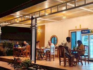 un grupo de personas sentadas en mesas en un restaurante en Star Garden Home, en Ko Jum