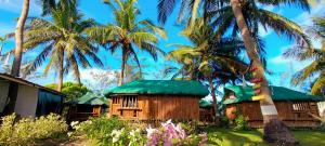 um grupo de casas com palmeiras ao fundo em Joyful Paradise Beach Resort em Nasugbu