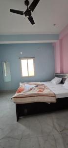 Un dormitorio con dos camas y un ventilador de techo. en Royal inn, en Patna