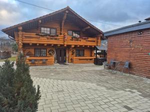 a log cabin with a patio in front of it at Casa de Munte in Vatra Dornei