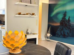 a dining room with a table with a vase on it at Aurora Home Rovaniemi in Rovaniemi