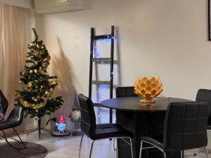 a dining room with a christmas tree and a table and chairs at Aurora Home Rovaniemi in Rovaniemi