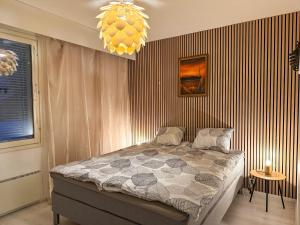 a bedroom with a bed and a chandelier at Aurora Home Rovaniemi in Rovaniemi