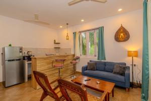 a living room with a blue couch and a table at Palmera Home Stay in Siolim