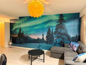 a living room with a wall mural of a winter forest at Aurora Home Rovaniemi in Rovaniemi