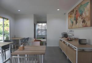 a restaurant with tables and chairs and a painting on the wall at Oh My Place in Chiang Rai