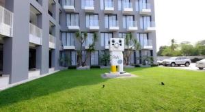 R Photo Hotel في Ban Noi Pho Kham: تمثال في العشب امام مبنى